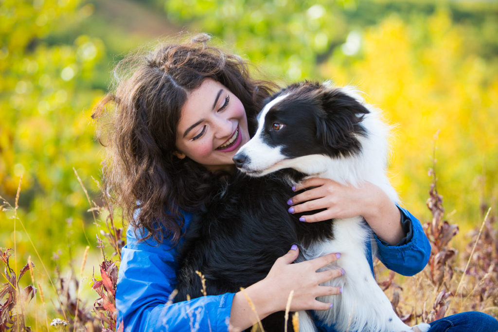 High school senior girl in a field with her dog