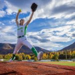 Savannah Johnson-7188-1200x800 girl in softball uniform pitching a softball with scattered clouds overhead