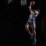 Spencer Love-6773-1200x800 boy in basketball uniform in the air dunking a basketball