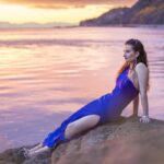Isabella Carner-8653website-min girl in a blue dress leaning back on a rock in sunset lighting