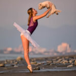 Anastasia Finch-0754 girl in a tutu while on pointe and holding her dog out in front of her