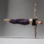 Augustine Hardison-7280 girl in a studio doing a one handed handstand parallel to the ground