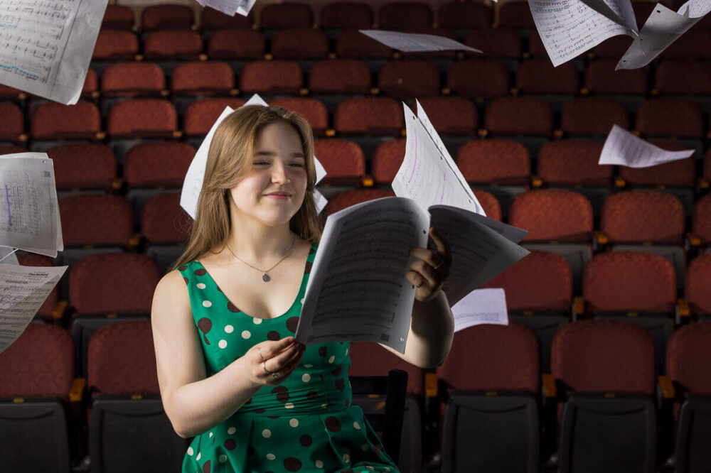 senior photo of a high school boy with a snowboard on a glacier
