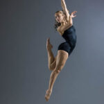 Gigi Schmidt-7130 girl in a black leotard jumping in a dance pose