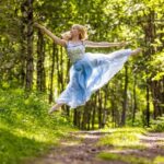 Ivy-Souja-4500-copy girl in a blue dress leaping on a path in the forest