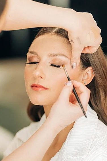 photo of a woman having professional makeup applied to her face
