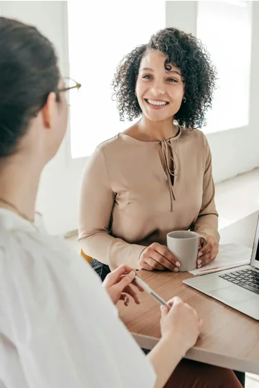 photo of an attractive middle aged woman smiling while drinking coffee