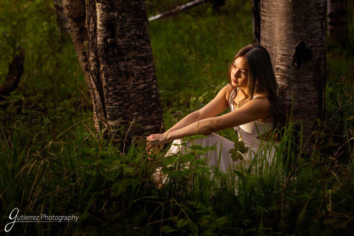 High school senior girls sitting in a golden hour light in a forest