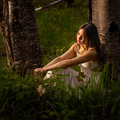 High school senior girls sitting in a golden hour light in a forest